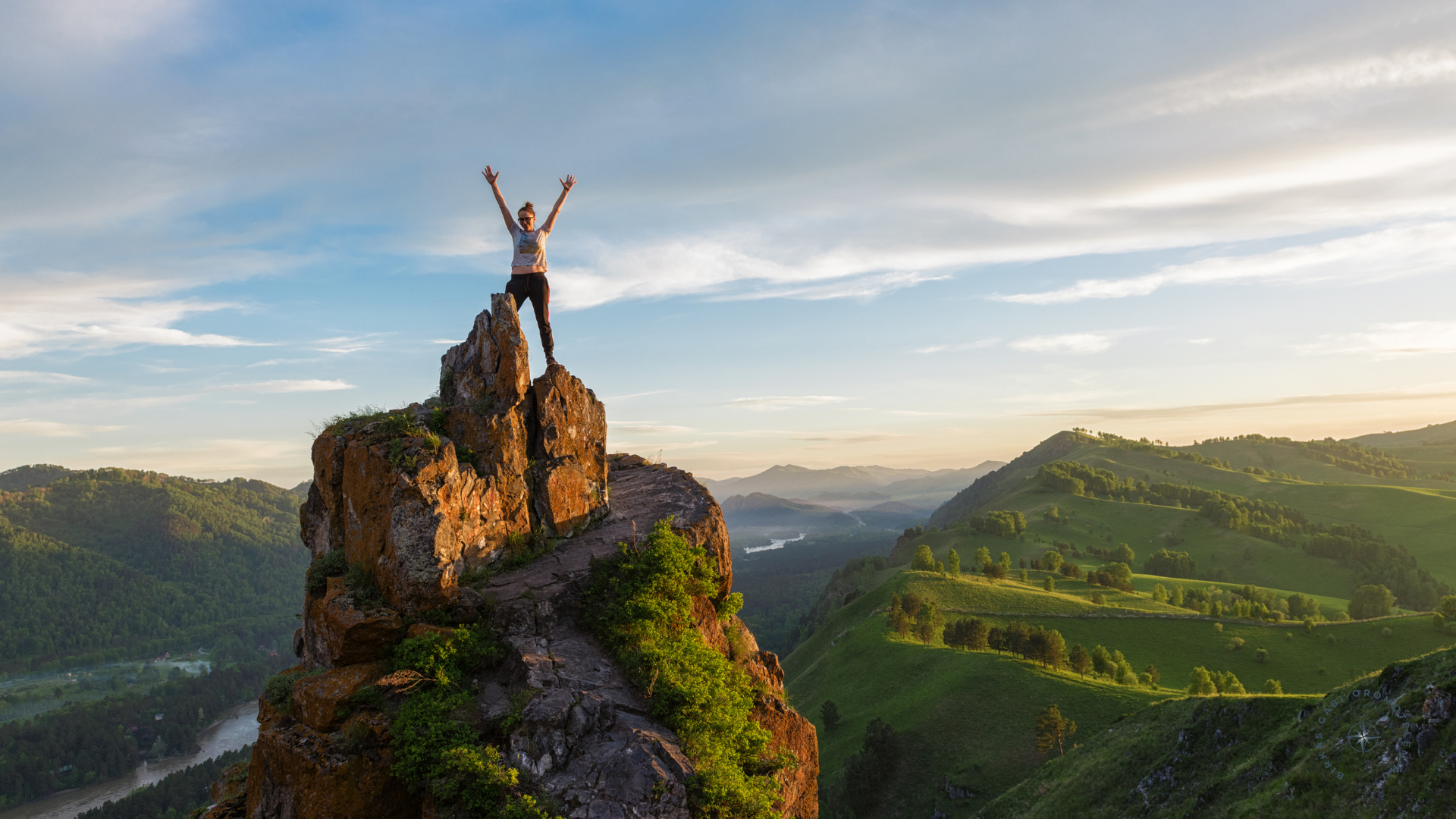 Tudatos női vezető áll a hegytetőn, karját felemelve – a szabadság és a jelenlét szimbóluma
