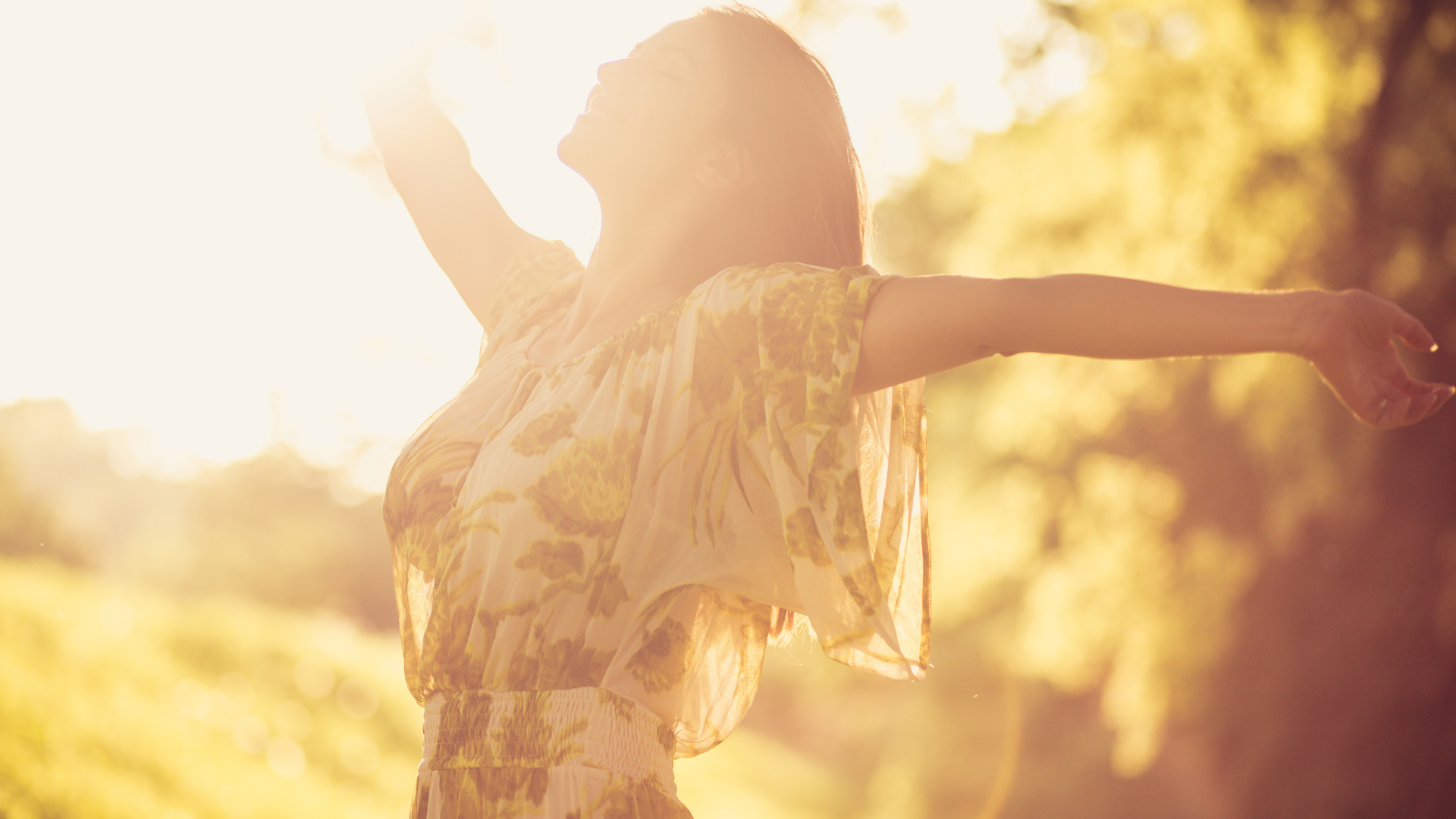 Nő napfényben, kitárt karokkal, mosolyogva – az örömből és könnyedségből való vezetés szimbóluma.